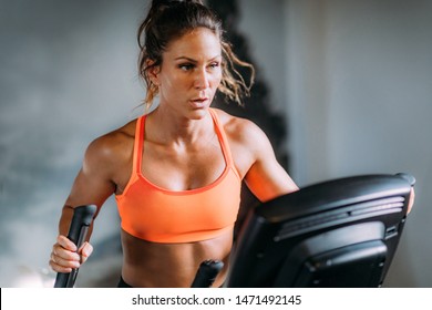 Woman Exercising on Elliptical Cross Trainer - Powered by Shutterstock