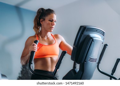 Woman Exercising on Elliptical Cross Trainer - Powered by Shutterstock