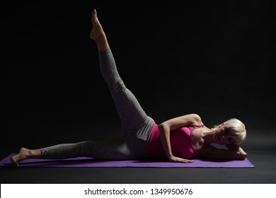 Woman Exercising Pilates. Side Lying Leg Raise Exercise.