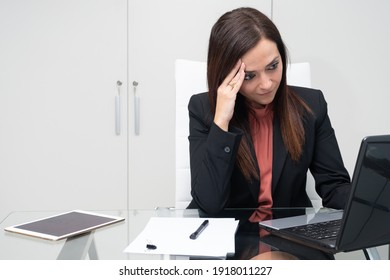 woman exhausted from work in her office in front of the laptop - selective focus
