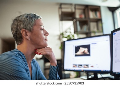 Woman experiencing neck pain while working at desk with dual monitors in office