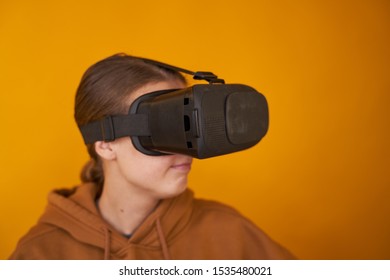 woman is experiencing a new game in virtual glasses. creative reality experience for games and business. on a yellow background. modern woman innovation and it industry