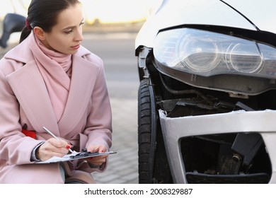 Woman Expert Filling Out Documents Near Broken Car On Street