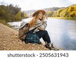 Woman explores new, magical places around the world, surrounded by nature. Female hiker crossing the forest creek. The concept of hiking, travel, vacation.