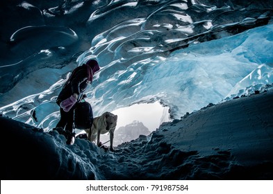 Woman exploring athabasca glacier cave in banff / jasper national park canada with  adventurous dog pet - Powered by Shutterstock