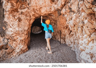 A woman exploring a coastal cave in Montenegro, blending ancient formations with stunning seaside views and rugged landscapes. - Powered by Shutterstock