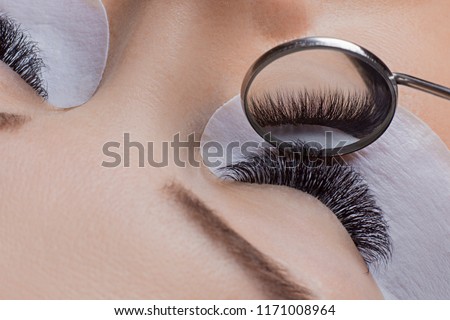 Woman eye with beauty lashes. Eyelash extension procedure.