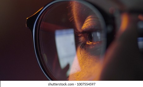 Woman Eye Looking Monitor, Surfing Internet. Woman With Glasses Eyes Looking At The Monitor, Surfing The Internet, Extreme Close-up, Dark Room. Close Up Of Woman In Glasses Watching Movie On Tablet