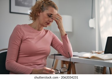 Woman with eyes hurting, sinus problem, headache, head pain, working from home troubles and issues.