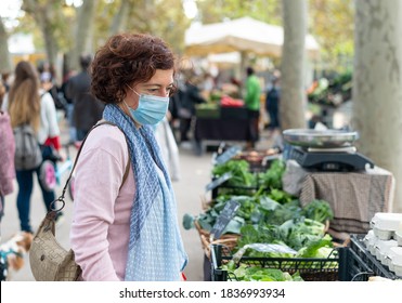 Woman With Face Mask Buying Vegetables At An Outdoor Market. New Normal Concept