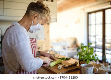 Woman With Face Mask Cooking Indoors At Home, Corona Virus Concept.