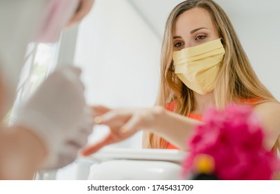 Woman With Face Mask During Manicure In Nail Salon