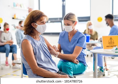Woman with face mask getting vaccinated, coronavirus, covid-19 and vaccination concept. - Shutterstock ID 1814780726