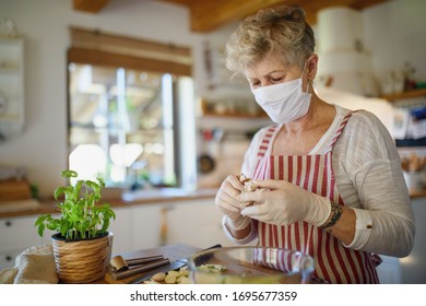 Woman With Face Mask And Gloves Cooking Indoors At Home, Corona Virus Concept.