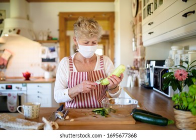 Woman With Face Mask And Gloves Cooking Indoors At Home, Corona Virus Concept.