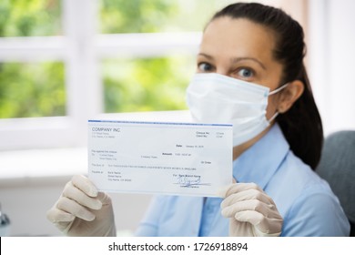 Woman In Face Mask Holding Paycheck Or Stimulus Check 