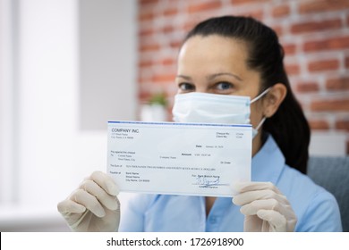 Woman In Face Mask Holding Paycheck Or Stimulus Check 