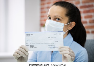 Woman In Face Mask Holding Paycheck Or Stimulus Check 