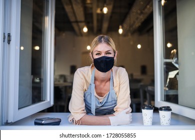 Woman With Face Mask Serving Coffee Through Window, Shop Open After Lockdown.