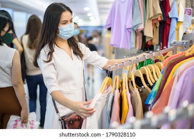 Woman With Face Mask Is Shopping Clothes In Shopping Center Woman With Face Mask Is Shopping Clothes In Shopping Center .