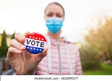 Woman With Face Mask Showing Vote Button At American Elections Outside.