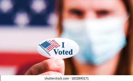 Woman With Face Mask Showing I Voted Sticker With American Flag. Extreme Close-up