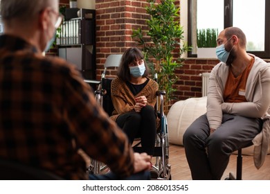 Woman With Face Mask Sitting In Wheelchair At Group Therapy Session. People With Alcohol Addiction Attending Aa Meeting Program To Receive Mental Health Help From Psychotherapist.