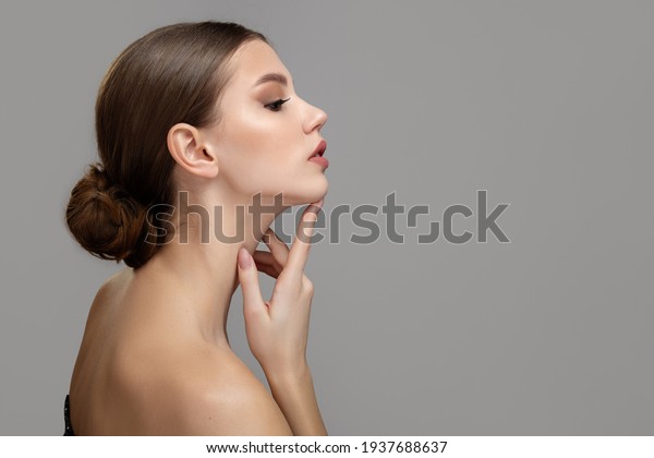 Woman face profile side view. Chin lift pointing\
with index finger