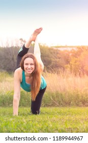 Woman Facing Camera In Bird Dog Yoga Pose Leg Lift Raise Outdoors In Nature Sunset Or Sunrise, Overexposed For Spiritual Light Effect Active Lifestyle Health Wellness Exercise Concept, Vertical Shot