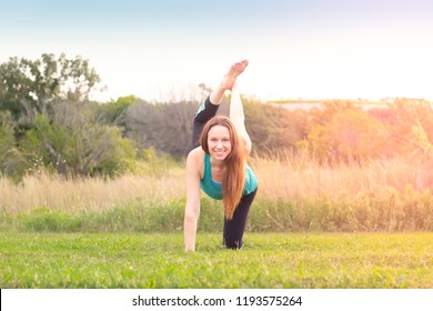 Woman Facing Camera Center In Yoga Pose Leg Lift Raise Outdoors In Nature Sunset Or Sunrise, Overexposed Spiritual Light Effect, Active Lifestyle Health Wellness Exercise Concept, Text Copy Space