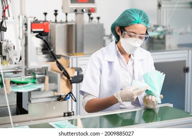 woman factory worker are producing medical face masks, counting and checking of quality from machine - Powered by Shutterstock