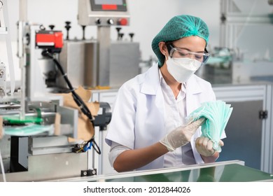 woman factory worker are producing medical face masks, counting and checking of quality from machine - Powered by Shutterstock