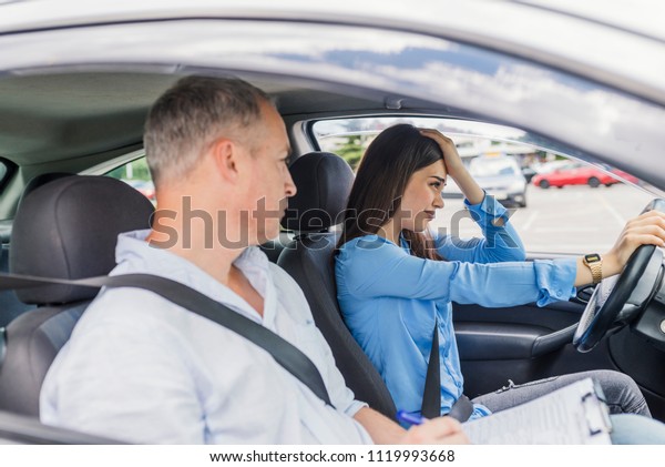 Woman failed on driving test. Driving school.\
Stressed and disappointed young woman failed on driving test.\
Student driver taking driving\
test