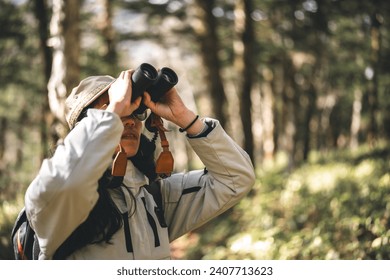 woman family walking in the forest to watching a bird in nature, using binocular for birding by looking on a tree, adventure travel activity in outdoor trekking lifestyle, searching wildlife in jungle - Powered by Shutterstock