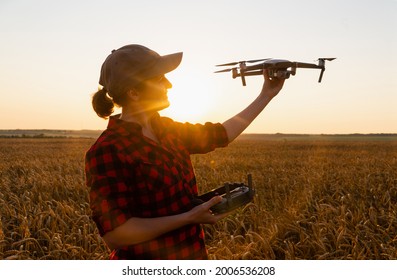 Woman farmer with drone on the wheat field. Smart farming and precision agriculture