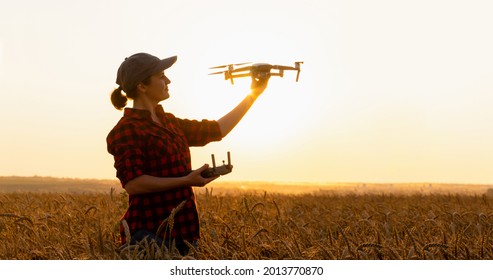 Woman Farmer With Drone On The Wheat Field. Smart Farming And Precision Agriculture