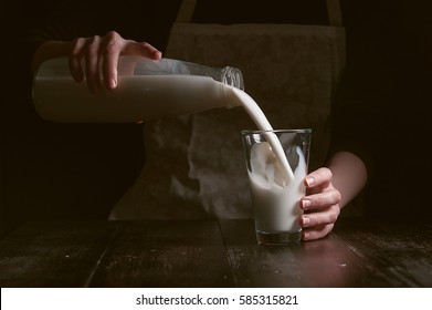 Woman Farmer Pours The Milk Into A Glass