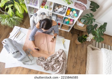 Woman fashion designer drawing sew pattern creation clothes textile workshop workplace desk top view. Female tailor dressmaker material fabric handcraft with ruler scissors electric sewing machine - Powered by Shutterstock