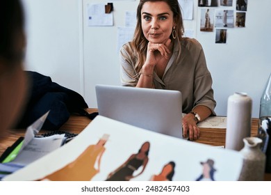 Woman, fashion designer and laptop with tailor for interview or discussion on ideas or design at boutique store. Female person with sketch of outfits for runway, planning or proposal on clothing line - Powered by Shutterstock