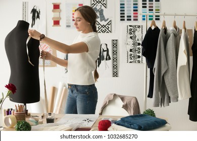 Woman fashion designer measuring mannequin, seamstress holding tape working with dummy in cozy creative design studio or tailor shop, dressmaking and sewing concept, exclusive unique clothes creation - Powered by Shutterstock