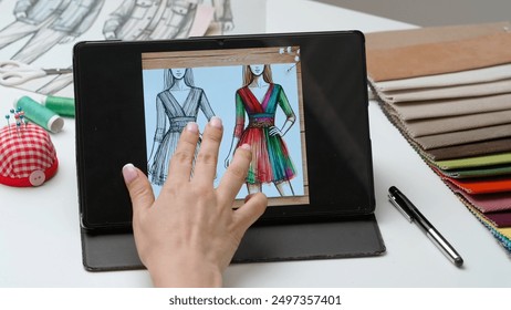 Woman fashion designer works on digital graphic tablet touch screen with illustration of clothing collection sketch. Creativity and modern technology. - Powered by Shutterstock