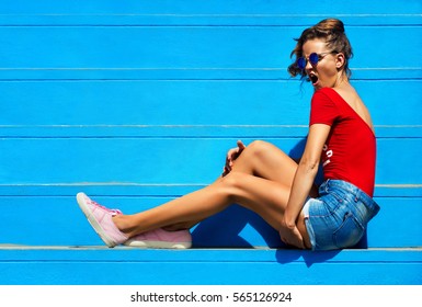 Woman Fashion. Photo Shoot On A Bright Blue Stairs. Outdoors