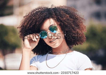 Woman, fashion and sunglasses on face outdoor in city for summer holiday and travel with a smile. Portrait of African person with natural hair or afro and trendy glasses at a park for freedom