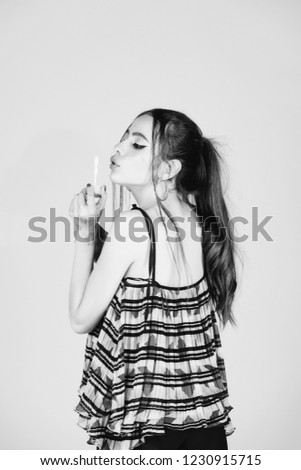 woman with fashionable makeup and hair blow in bubble blower on pink studio background