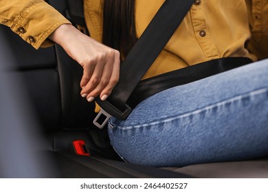 Woman fastening safety seat belt inside modern car, closeup - Powered by Shutterstock