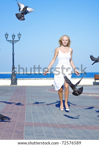 woman feeding birds at the beach