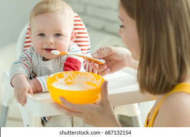 A Woman Is Feeding A Child 