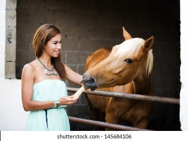 Woman feeding a horse in the countryside