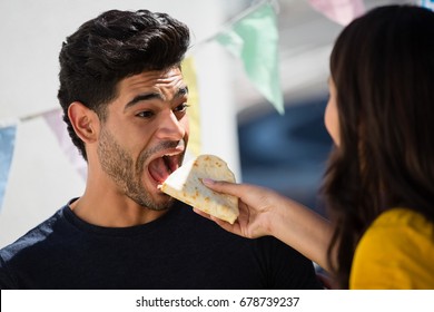 Woman feeding tortilla to friend by food truck - Shutterstock ID 678739237