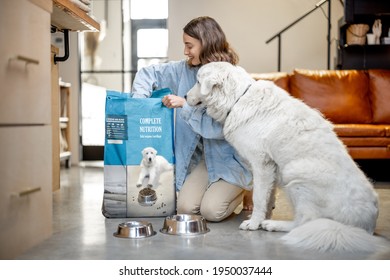 Woman Feeds A Dog With Dry Food At Home